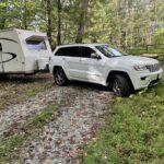 Jeep Grand Cherokee pushing a 24-foot RV into place. 